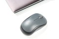Computer wireless mouse next to a laptop on a white table close-up. electronic personal industry Royalty Free Stock Photo