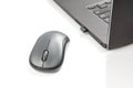 Computer wireless mouse next to a laptop on a white table close-up. electronic personal industry Royalty Free Stock Photo