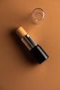 Concealer stick, on geometric backgrounds, in shades of brown. Product