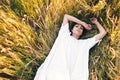 Conceived Beautiful young woman lying in the grass, wearing a white dress. Nature, summer holidays, vacation and people Royalty Free Stock Photo