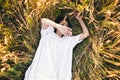 Conceived Beautiful young woman lying in the grass, wearing a white dress. Nature, summer holidays, vacation and people Royalty Free Stock Photo