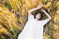 Conceived Beautiful young woman lying in the grass, wearing a white dress. Nature, summer holidays, vacation and people Royalty Free Stock Photo
