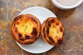 Conceived with the morning coffee and cakes Pasteis de nata, typical pastry from Portugal on natural marble surface. Royalty Free Stock Photo