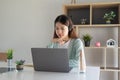 Concentrate asian gial freelancer wearing headset, communicating with client via video computer call. Millennial Royalty Free Stock Photo