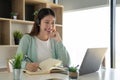 Concentrate asian gial freelancer wearing headset, communicating with client via video computer call. Millennial Royalty Free Stock Photo