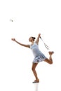 Concentrate young woman, badminton athlete in motion playing isolated over white background. Winning game