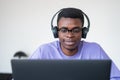 Concentrated African American student sitting listening to podca Royalty Free Stock Photo