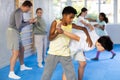 African teenager practicing painful armlock in sparring with boy at self defence training