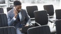 Concentrated afro businessman working on laptop in empty conference hall Royalty Free Stock Photo