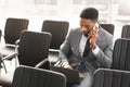 Concentrated afro businessman working on laptop in empty conference hall Royalty Free Stock Photo