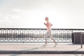 Concentrated aged woman running and spending time on fresh air.