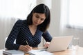 Focused Asian girl study on laptop making notes Royalty Free Stock Photo