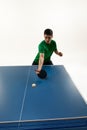 Concentrated athlete, Asian man with paddle ready for table tennis shot against white background. Tense moment. Action.