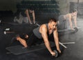 Man doing wheel rollout exercise at workout routine in gym