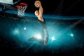 Concentrated basketball player in black jersey makes reverse slam dunk Royalty Free Stock Photo