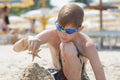 Concentrated beach boy building sand castle with starfish on top