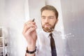 Concentrated bearded businessman in shirt touching screen interface