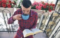 Concentrated bearded man reading books and drinking coffee or tea Royalty Free Stock Photo