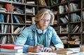 Concentrated bearded young man glasses sit library write essay education concept Royalty Free Stock Photo