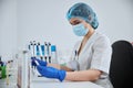 Serious lab technician examining a clinical specimen in her hand