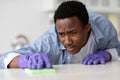 Concentrated black guy house-keeping attendant cleaning table