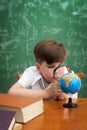 Concentrated boy examines globe Royalty Free Stock Photo