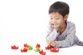 Concentrated boy plays paper ships on table Royalty Free Stock Photo