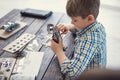 Concentrated boy sitting alone and making metal car model Royalty Free Stock Photo