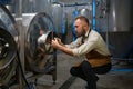 Concentrated brewer working with metallic vats in industrial brewery Royalty Free Stock Photo