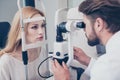 Concentrated brunet bearded optician with non contact tonometer Royalty Free Stock Photo