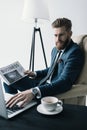 Concentrated businessman in armchair working on laptop Royalty Free Stock Photo