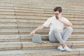 Thoughtful young businessman using a laptop and phone on stairs Royalty Free Stock Photo