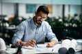 Concentrated busy handsome millennial islamic male engineer with beard in glasses, think about project