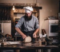 Concentrated chef kneading dough in the kitchen. Royalty Free Stock Photo