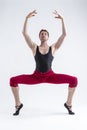 Concentrated Contemporary Ballet Dancer Flexible Athletic Man Posing in Red Tights in Ballanced Dance Pose With Hands Circled on