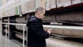Focused customer browsing smartphone, comparing linoleum samples while shopping in hardware store, searching product Royalty Free Stock Photo