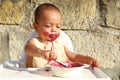 Concentrated messy baby boy eating blueberry cake Royalty Free Stock Photo