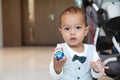 Concentrated cute toddler boy in suit with bowtie showing toy care