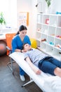 Concentrated dark-haired masseuse processing neck of little boy