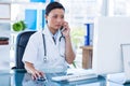 Concentrated doctor having phone call and using her computer Royalty Free Stock Photo