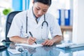 Concentrated doctor writing on notebook