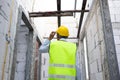 Concentrated engineer in safety vest at construction site wearing a hard helmet hat. Royalty Free Stock Photo