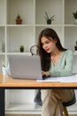 Concentrated female auditor holding magnifying glass examining the numerical data on financial document Royalty Free Stock Photo