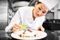 Concentrated female chef garnishing food in kitchen Royalty Free Stock Photo