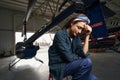 Focused and tired woman airframe engineer during the break in aviation garage Royalty Free Stock Photo