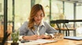 Concentrated female financial advisor preparing contract document for client on her working desk Royalty Free Stock Photo