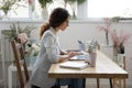 Concentrated female small business owner using laptop at work desk