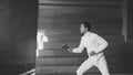 Young concentrated fencer man practice fencing exercises and training for Olympic games competition in studio indoors