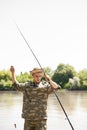 Concentrated fisherman fiddling with fishing tackle, while going fishing outdoors. Royalty Free Stock Photo