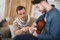 concentrated focused mature father helping student to play guitar Royalty Free Stock Photo